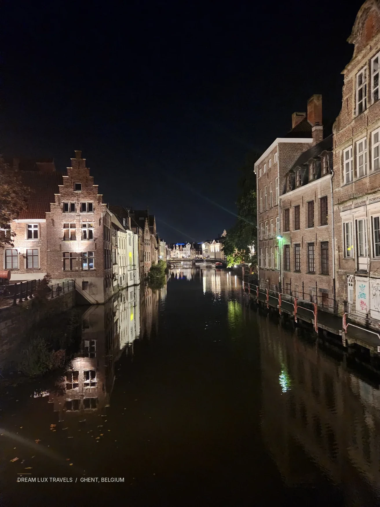 Quiet canal and illuminated medieval buildings in Ghent at night