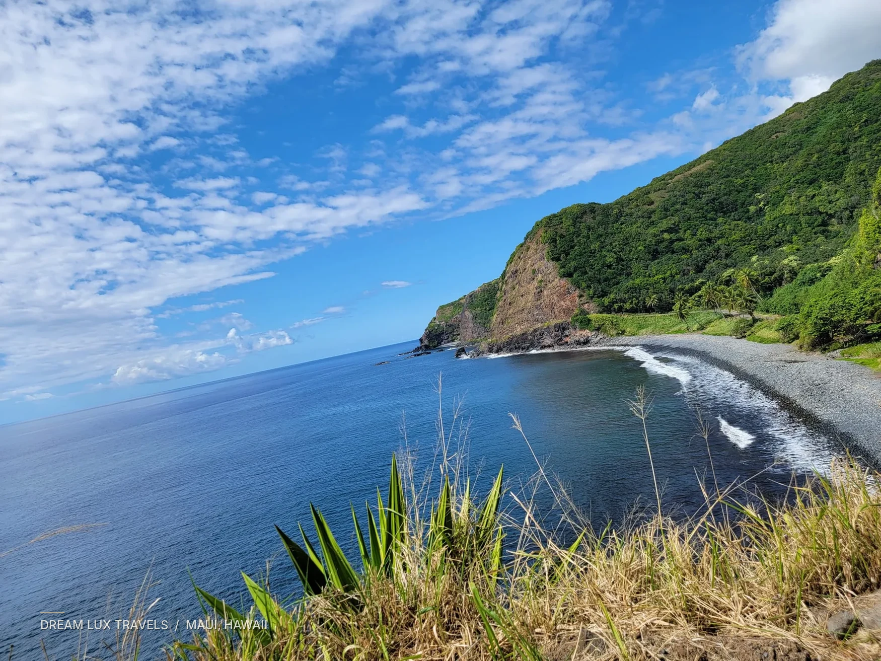 Curved black-sand coastline and lush headlands along Maui’s Road to Hana.